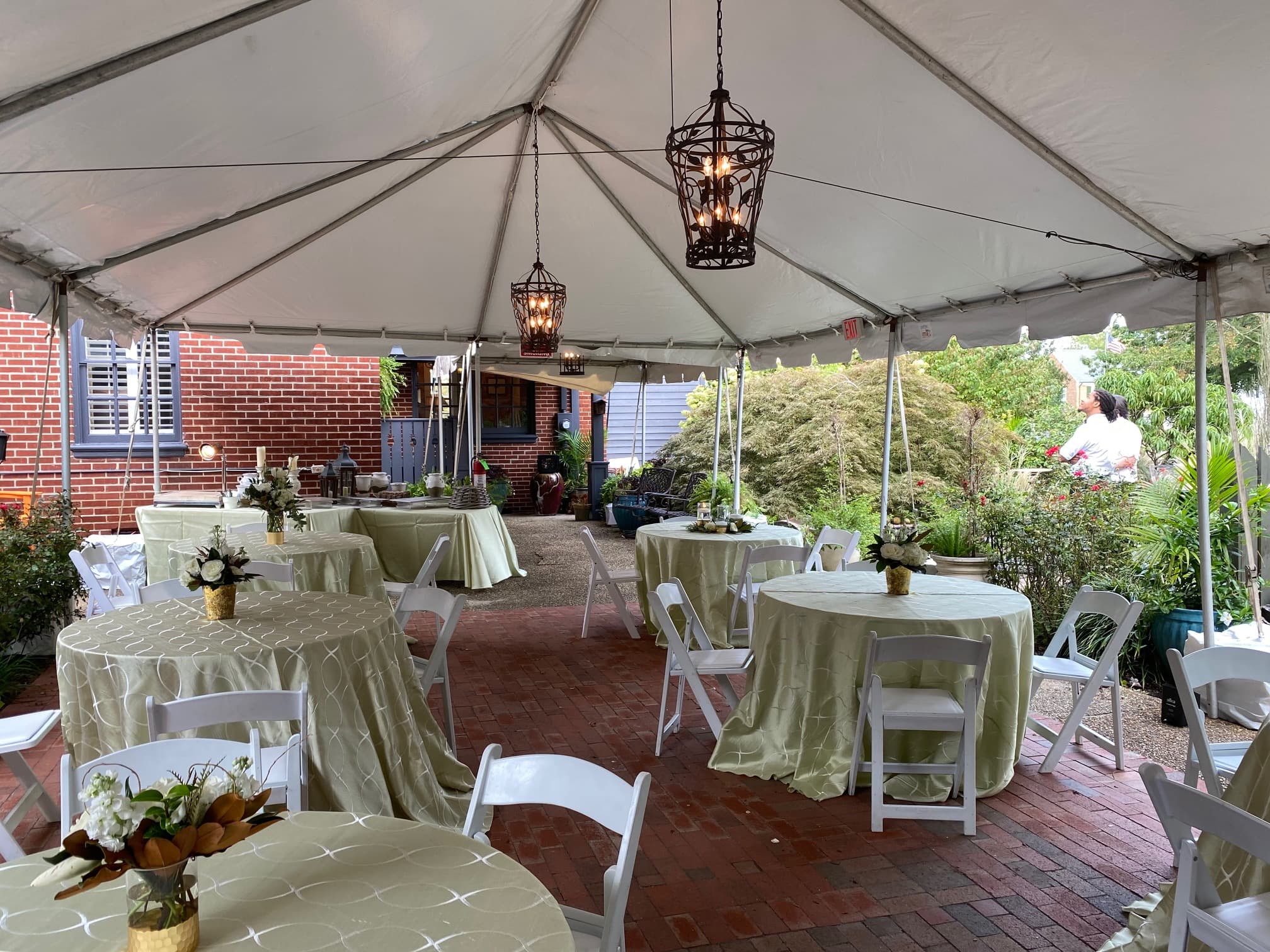 A decorated tent with tables and chairs set for an outdoor event.