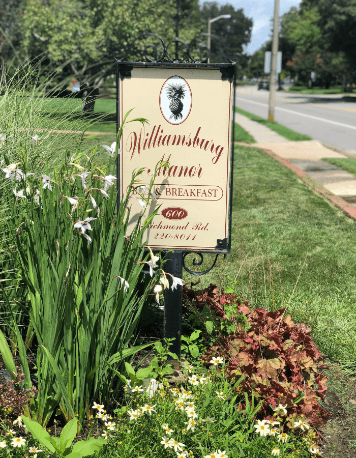 Sign for "Williamsburg Manor Bed & Breakfast" beside a landscaped area.