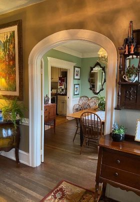 Arched doorway of a home showing entry way table and view into a dining room and kitchen
